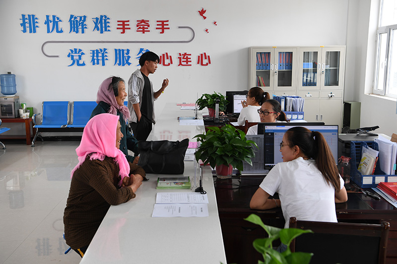 在甘肃省武威市古浪县黄花滩生态移民区富民新村党群服务中心便民大厅,村民前来办理业务(2019年8月22日摄)。新华社记者 范培珅 摄